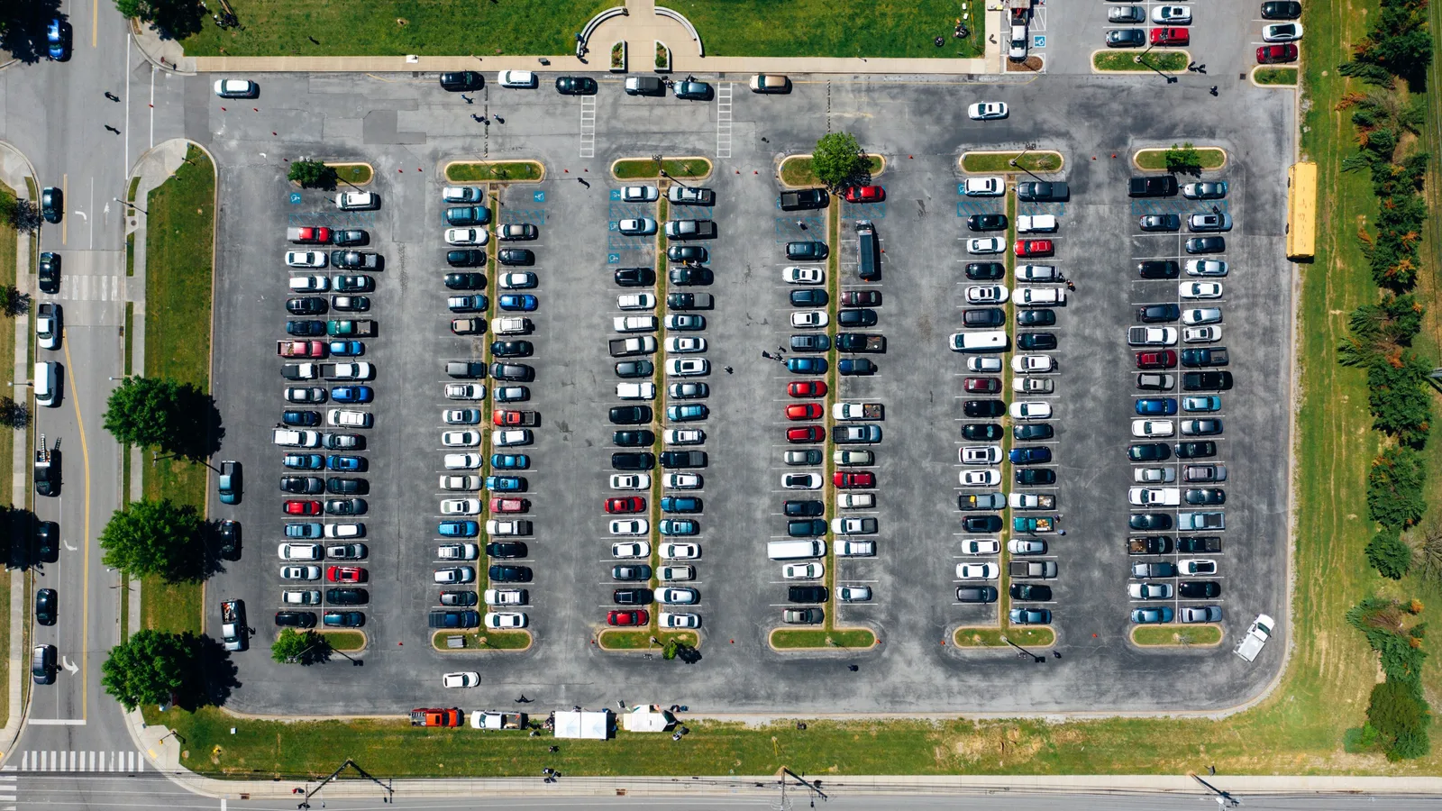 Overhead aerial view of cars parked in neat rows across a large lot