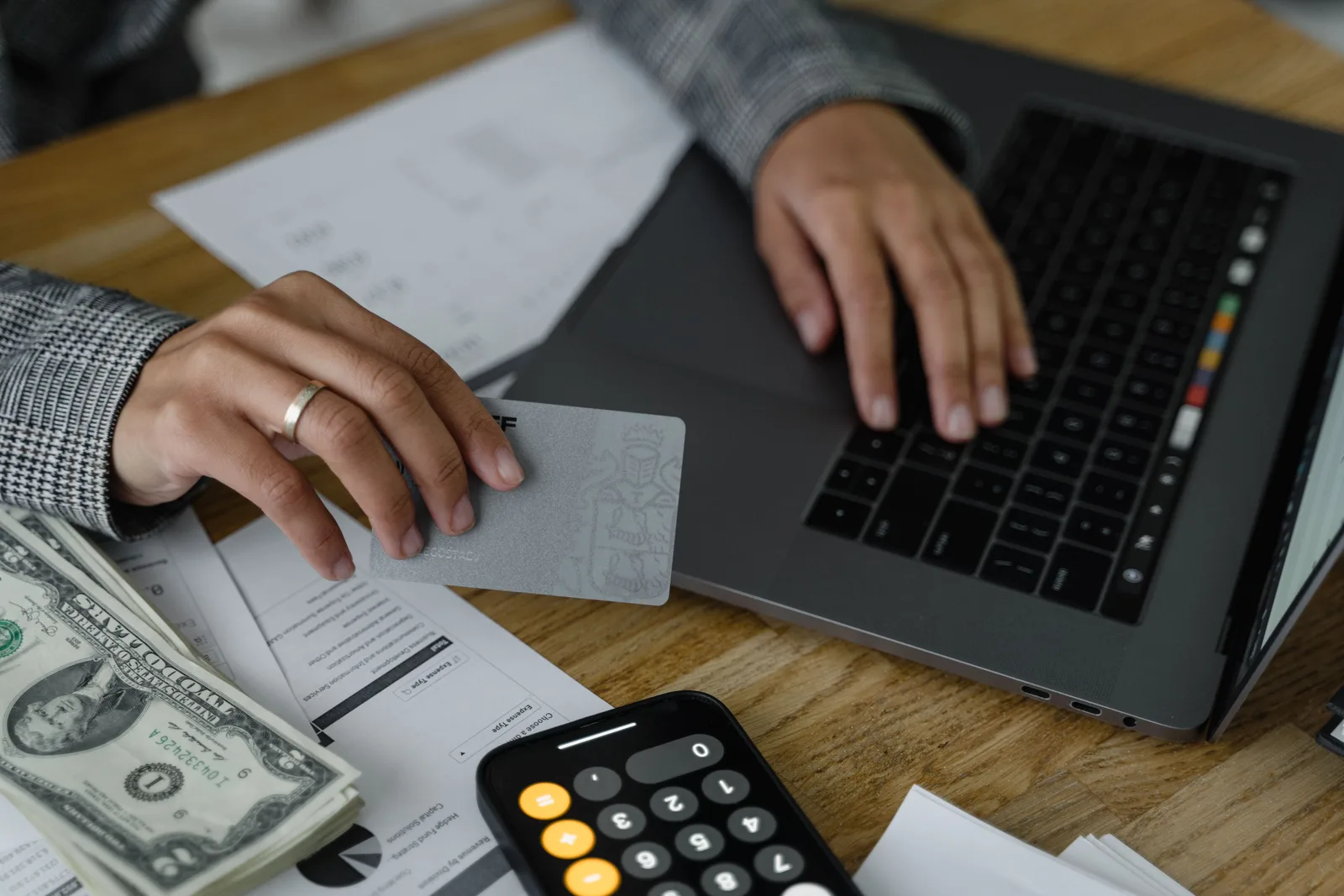 A person reviewing a credit card statement at a home kitchen table