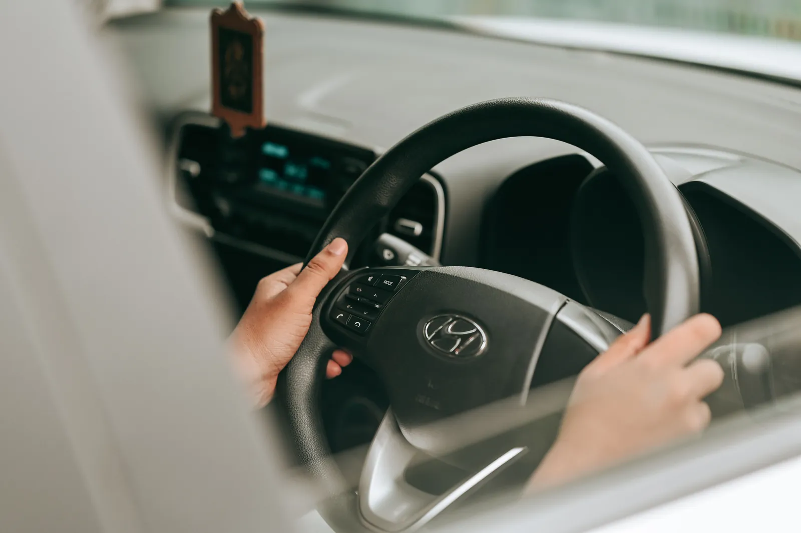 Driver behind the wheel of a car on a suburban street