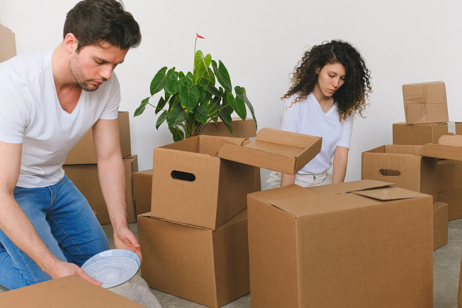 A young couple carrying moving boxes into a California apartment