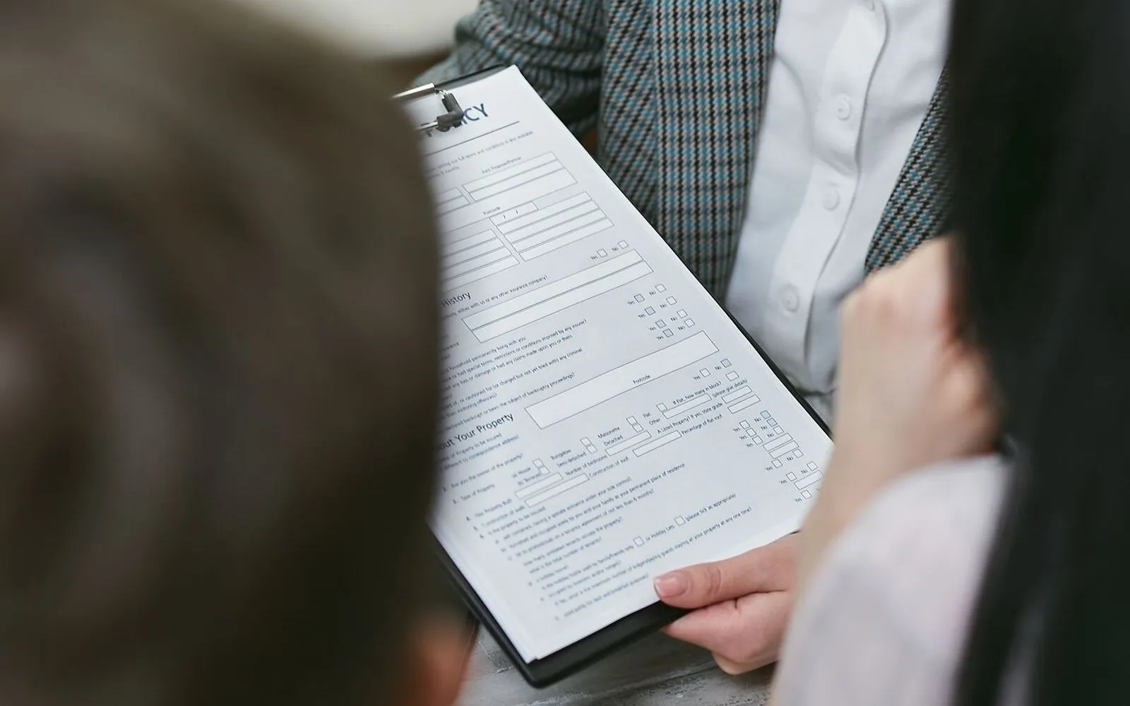 A person holding a printed contract document and reviewing the pages