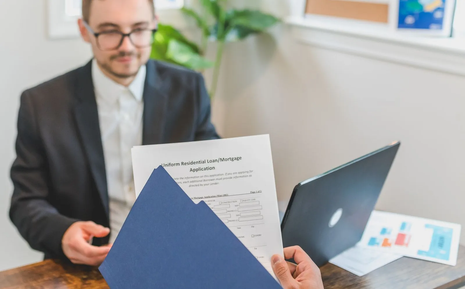 Two people reviewing mortgage loan documents across a table