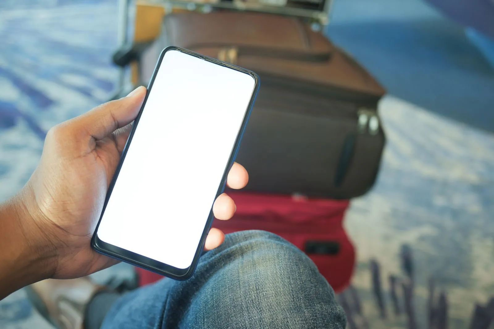 A person holding a smartphone with a travel booking screen