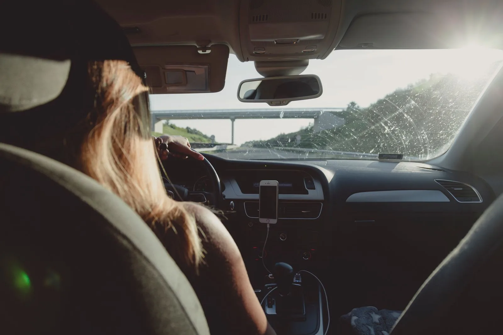 Woman driving a car on an open highway on a clear day