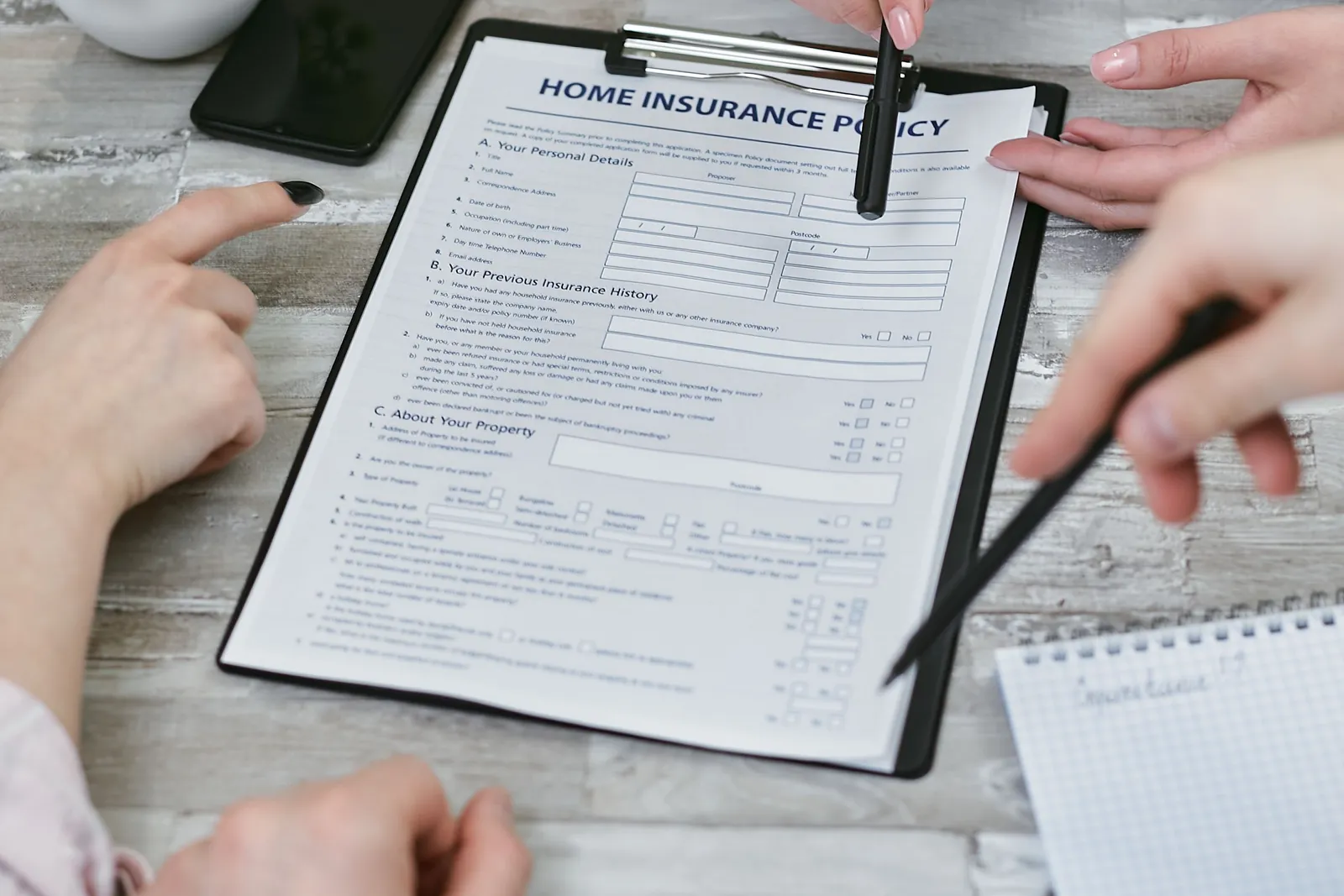 Two people going over a home insurance policy document at a table