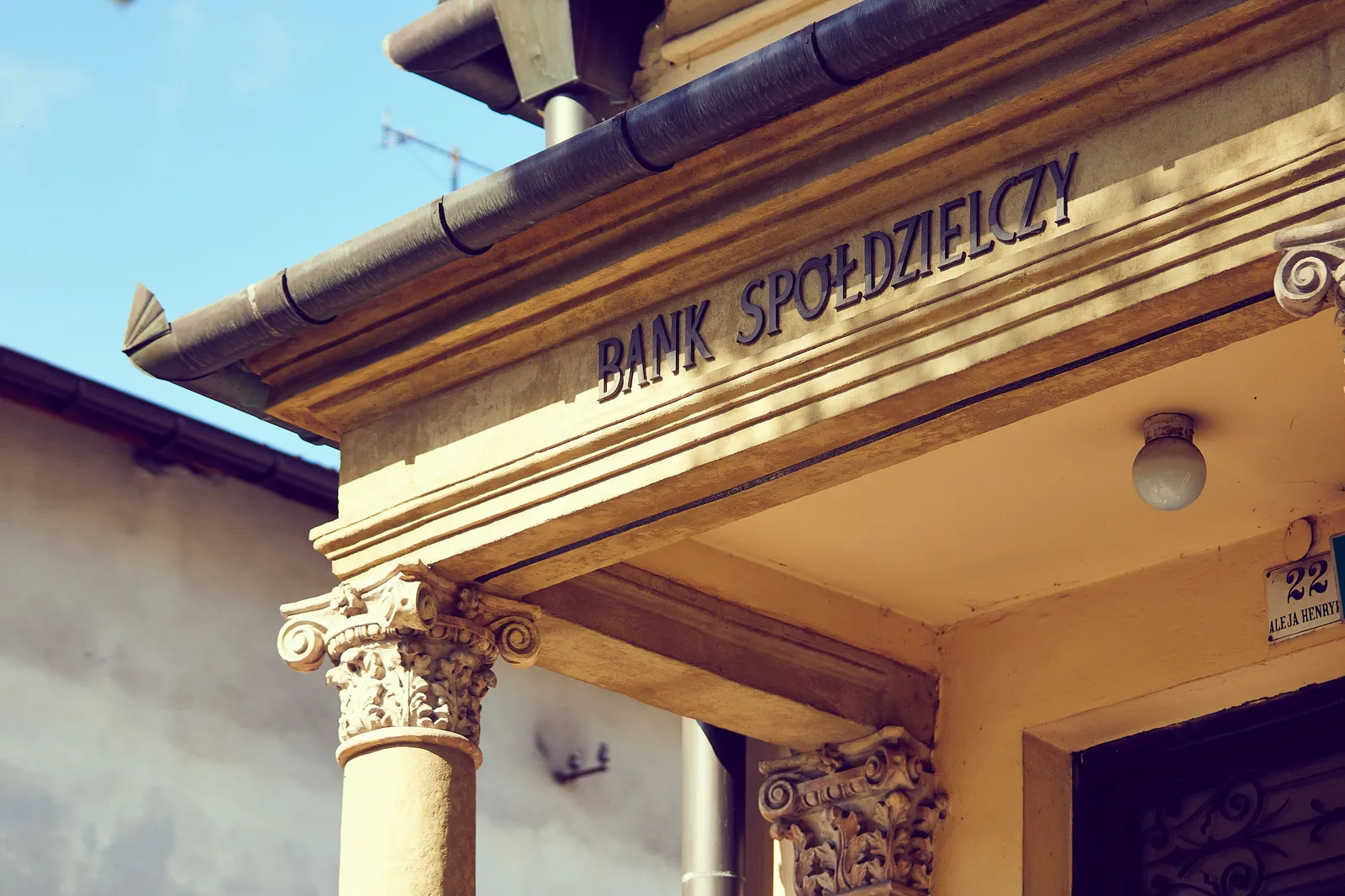 Neoclassical bank building facade with lettering carved above the entrance