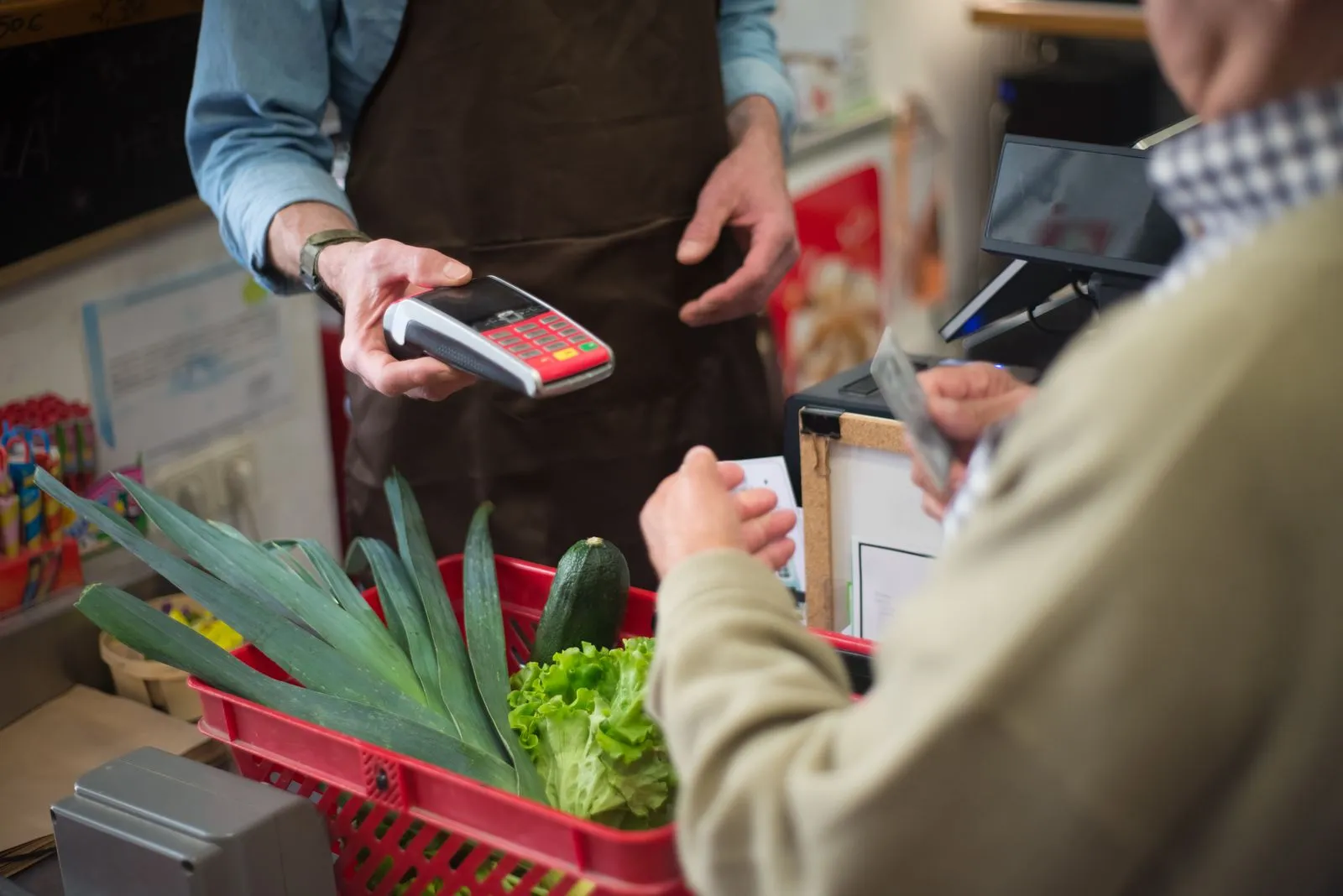 Customer paying for groceries with a card at a store checkout