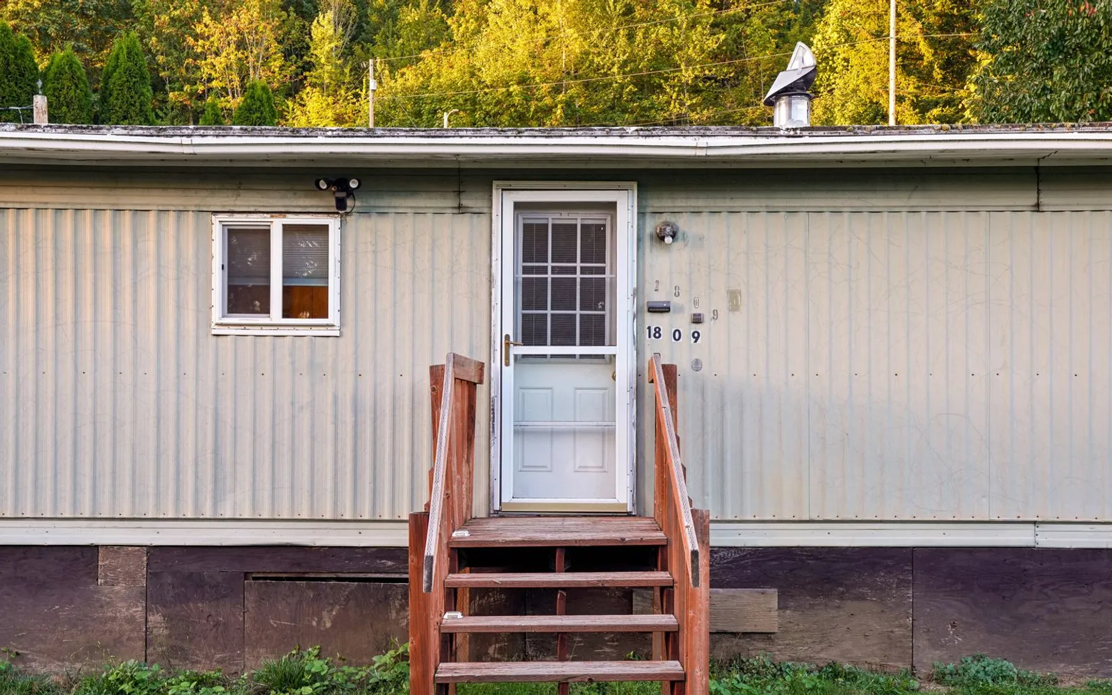Single-section manufactured home with metal siding, skirting and wooden entry steps