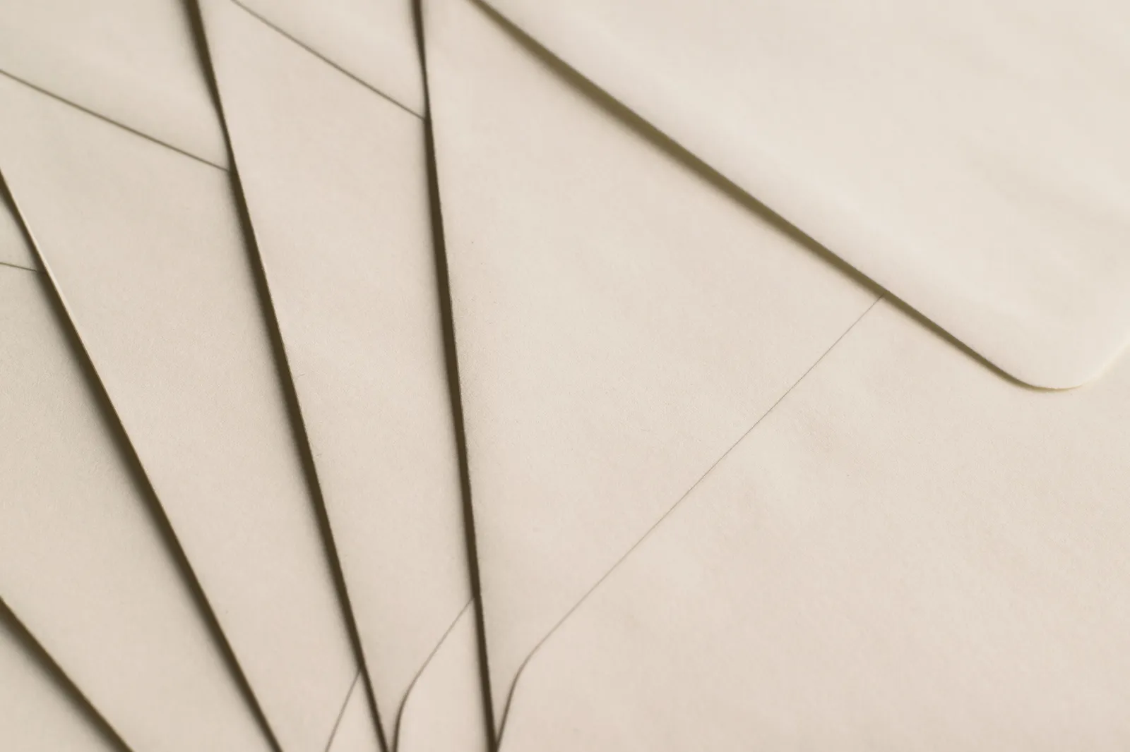 Plain beige envelopes arranged in a row on a neutral surface