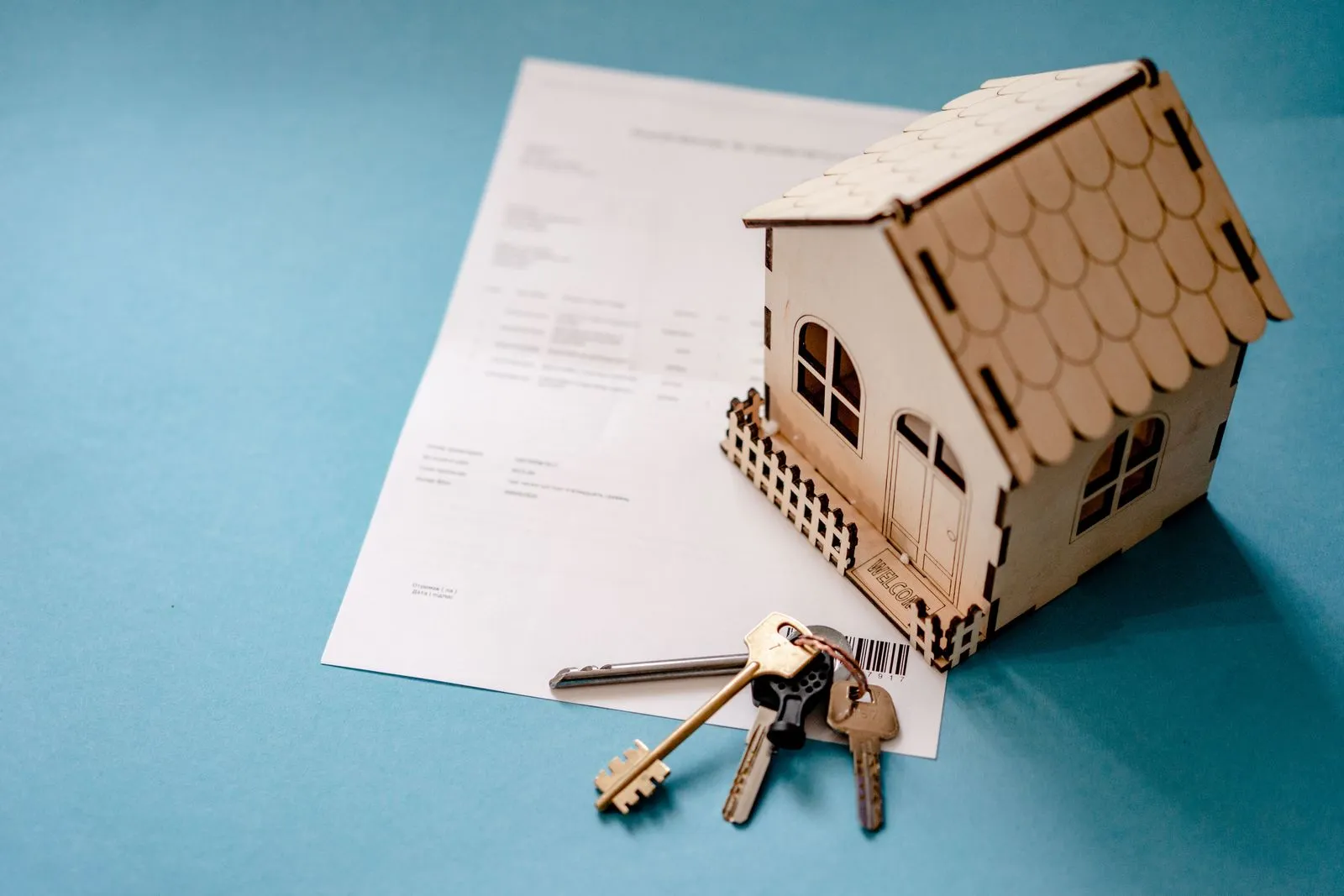 Two people at a kitchen table reviewing a home sale contract with a calculator and pen
