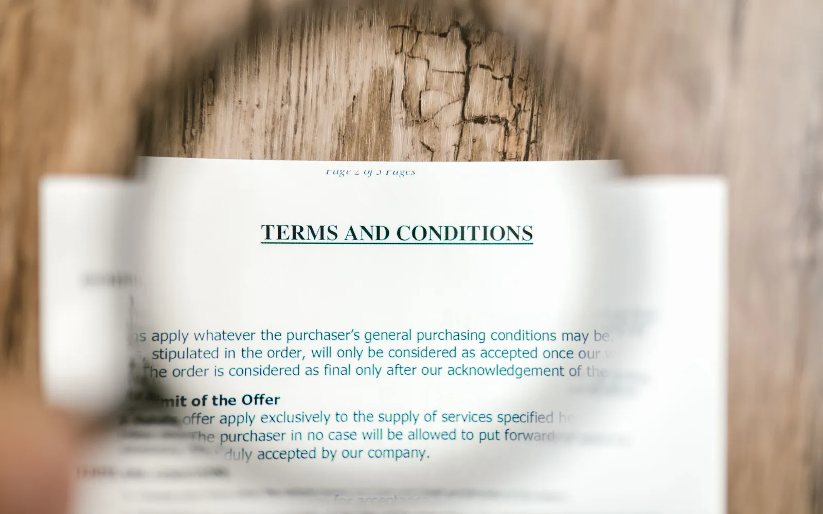 Magnifying glass held over the terms and conditions page of a contract