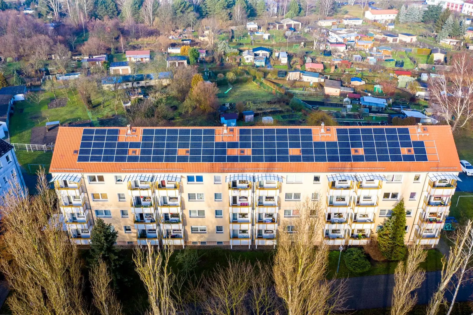 Aerial view of an apartment complex with solar panels on the rooftop