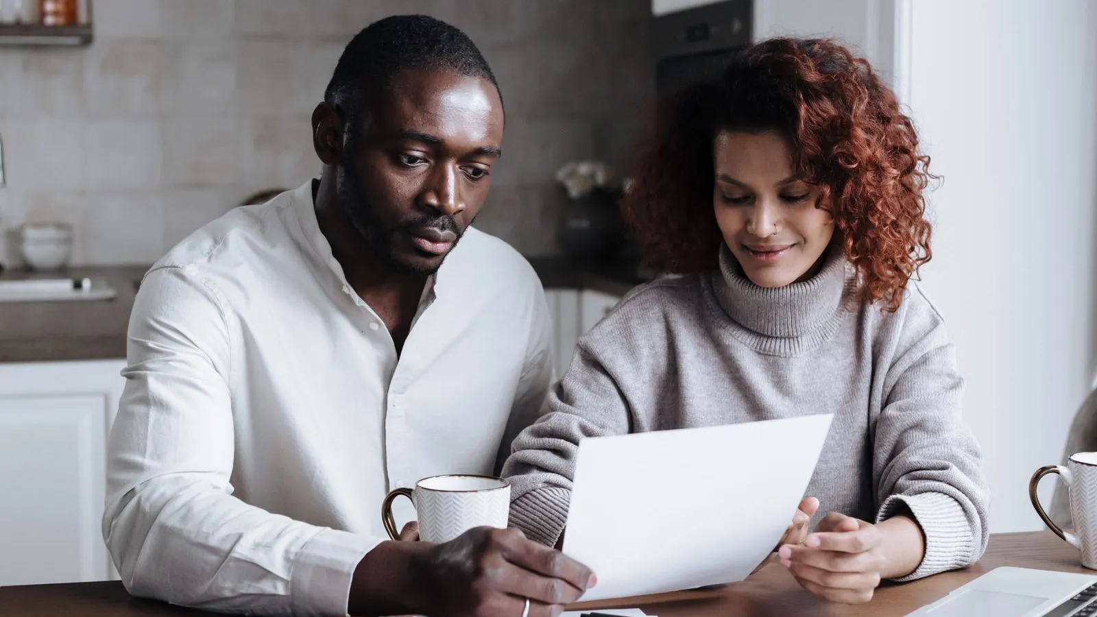 Couple reviewing paperwork together at a kitchen table