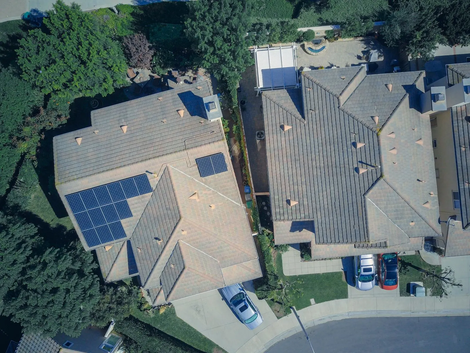 Aerial view of two suburban houses with solar panels covering their roofs