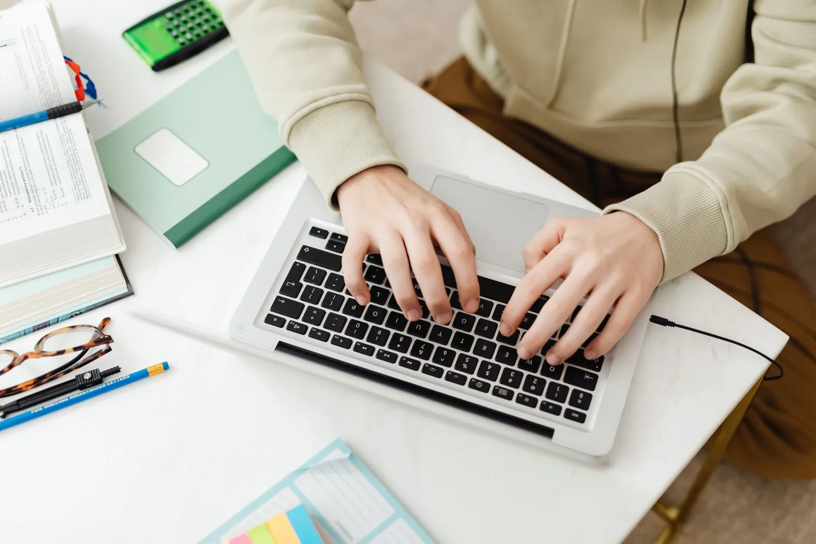 A laptop on a desk with a mug and notebook, open to an online banking screen
