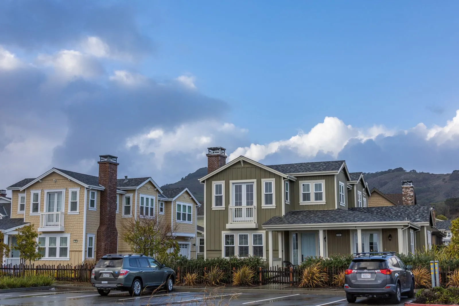 Cars parked outside modern suburban homes on a quiet residential street